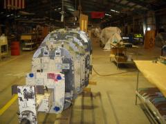 Factory tail cone jig, note new fuselages covered in tarps.